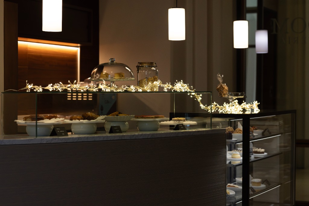 Interior acogedor de la pastelería Bloom con vitrinas y luces decorativas